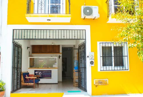 a yellow building with an open door and a yellow wall at Hotel OM DownTown in Santa Cruz Huatulco