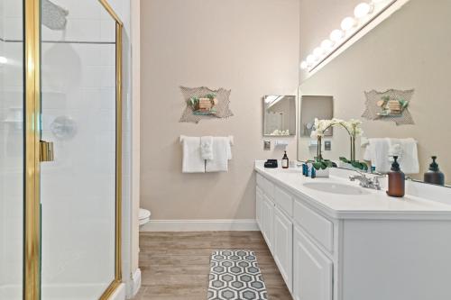 a bathroom with a white sink and a shower at Cristina's Tropical Villa/ Just minutes from Disney! in Kissimmee