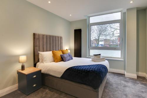Un dormitorio con una cama grande y una ventana en New London Life Executive Apartments, en Chelmsford