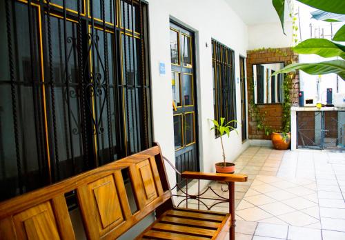 a porch with a bench and a door with a plant at Hotel OM DownTown in Santa Cruz Huatulco