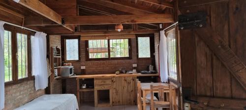 a room with a kitchen with wooden walls and windows at Cabañas Monoambiente La Foresta, en Mar de las Pampas in Mar de las Pampas