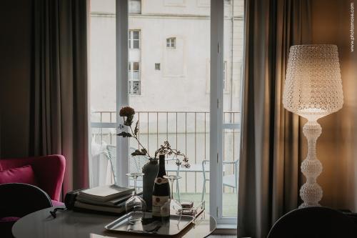 a room with a table with a lamp and a window at Romantique "comme à Venise" au bord de l'eau avec parking in Metz