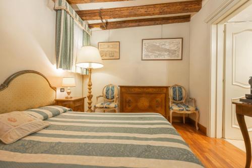 a bedroom with a bed and two chairs at Cà Valeri in Venice