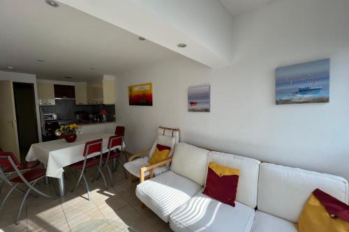 sala de estar con sofá blanco y mesa en Appartement Camargue Village, en Le Grau-du-Roi