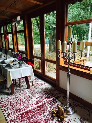 a dining room with a table and chairs and windows at Johanneshof Gästehaus in Hockenheim