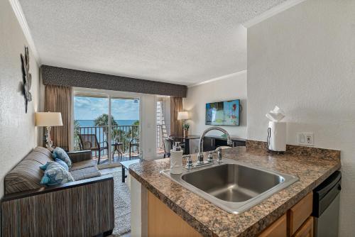 uma cozinha com um lavatório e uma sala de estar em Wake up to Ocean Views from your private balcony em Tampa