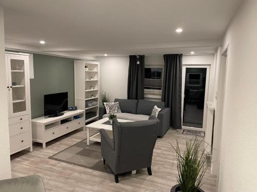 a living room with a couch and a tv at Haus Mariechen in Hooksiel