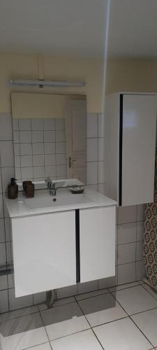cocina blanca con lavabo y espejo en Villa Soline, en Rivière-Pilote