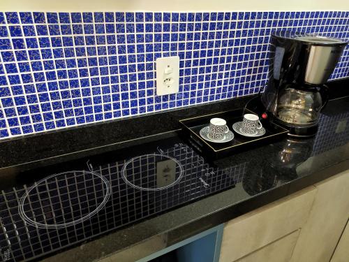 a black counter top with a coffee maker on it at Riviera Flat in Bertioga