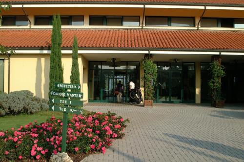a sign in front of a building with pink flowers at Hotel Excelsior in Cervia