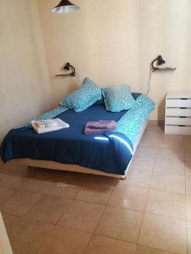 1 cama con sábanas y almohadas azules en una habitación en Departamento Mi casa en Mendoza en Godoy Cruz