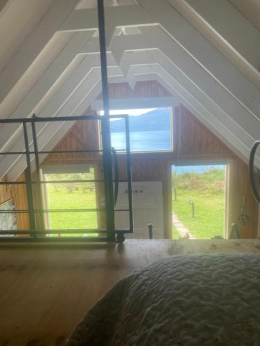 um quarto com uma grande janela num sótão em Cabañas EL CIERVO, Los Riscos, Puerto Varas em Puerto Varas