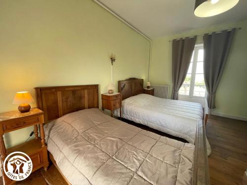 ein Schlafzimmer mit 2 Betten und einer Lampe auf einem Tisch in der Unterkunft Gîte Le Champ-Saint-Père, 4 pièces, 8 personnes - FR-1-426-239 in Le Champ-Saint-Père