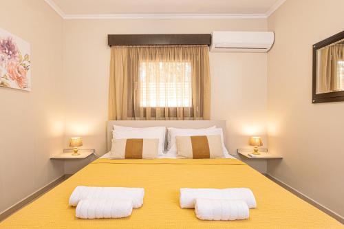 a bedroom with a large yellow bed with two pillows at Maria's Luxurious Villa in Koskinou in Koskinou