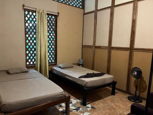 a room with two beds and a fan and a window at Chilamate Rainforest Eco Retreat in Puerto Viejo