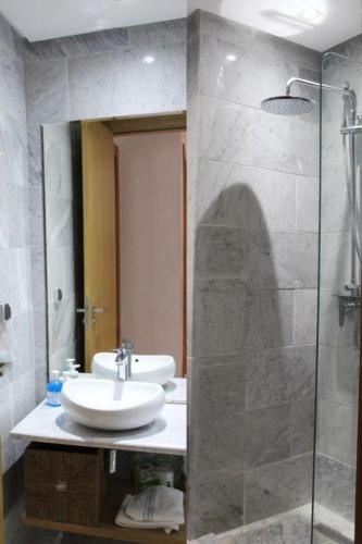 La salle de bains est pourvue d'un lavabo et d'une douche en verre. dans l'établissement ANOUAL PLAZZA - 2 BEDROOMS APPARTMENT, à Casablanca