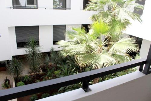 - un balcon avec des palmiers en face d'un bâtiment dans l'établissement ANOUAL PLAZZA - 2 BEDROOMS APPARTMENT, à Casablanca