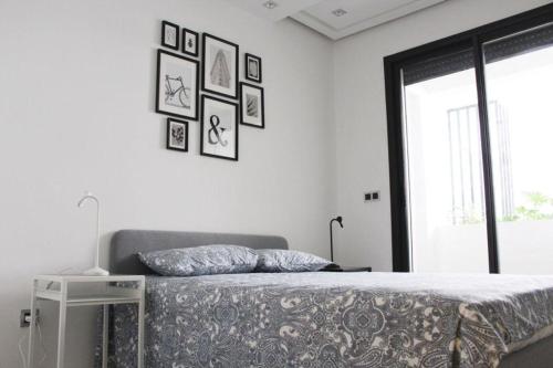 - une chambre avec un lit et des photos sur le mur dans l'établissement ANOUAL PLAZZA - 2 BEDROOMS APPARTMENT, à Casablanca