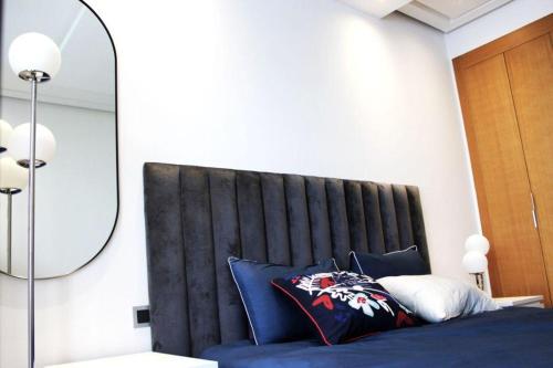 - une chambre dotée d'un lit avec des draps bleus et un miroir dans l'établissement ANOUAL PLAZZA - 2 BEDROOMS APPARTMENT, à Casablanca