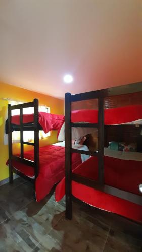托塔的住宿－Hospedaje Maria Valentina，一间卧室配有两张双层床,铺有红色床单
