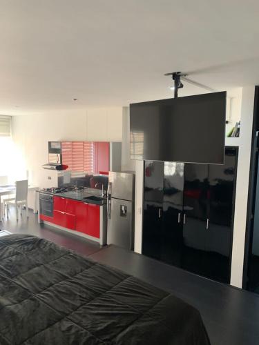 een kamer met een keuken met rode kasten en een bed bij Angolo Loft in Bogota