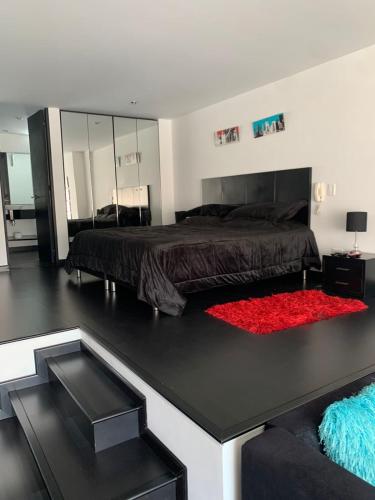een slaapkamer met een bed en een rood tapijt bij Angolo Loft in Bogota
