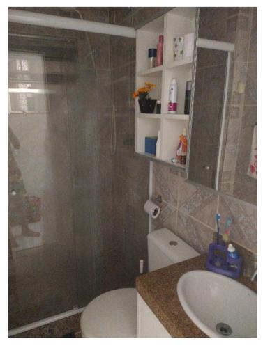 y baño con ducha, aseo y lavamanos. en Apartamento recreio, en Río de Janeiro