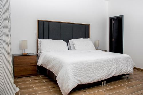 a large bed with a black headboard in a bedroom at Rá Ngu in Ixmiquilpan