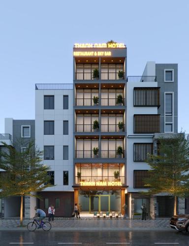 a tall building with people walking in front of it at Thanh Nam Hotel in Dong Quan