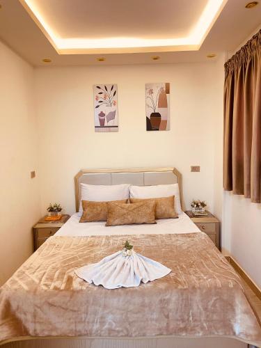 ein Schlafzimmer mit einem Bett mit einem Kleid drauf in der Unterkunft El mansour hotel apartmen 91 in Mansoura