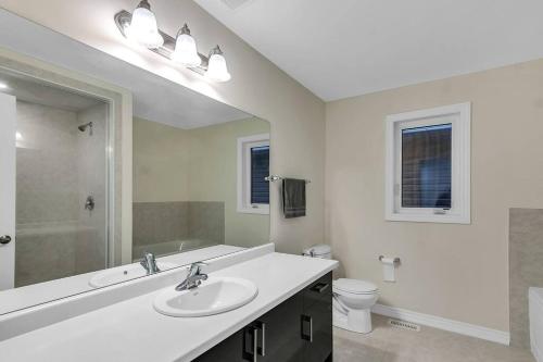 La salle de bains blanche est pourvue d'un lavabo et de toilettes. dans l'établissement Treasure in Brant - 4 Bedroom Detached House, à Paris