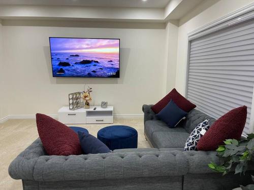 a living room with two couches and a flat screen tv at Treasure in Brant - 4 Bedroom Detached House in Paris