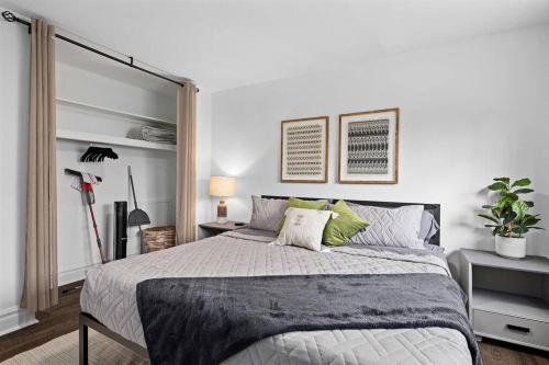 ein Schlafzimmer mit einem großen Bett mit grünen Kissen in der Unterkunft Brand New 1BR Flat, Cozy King Suite in Mount Clemens