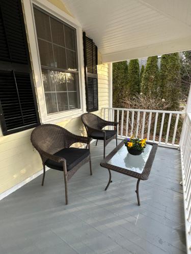 two chairs and a table on a porch at Heritage House Niagara in Niagara on the Lake