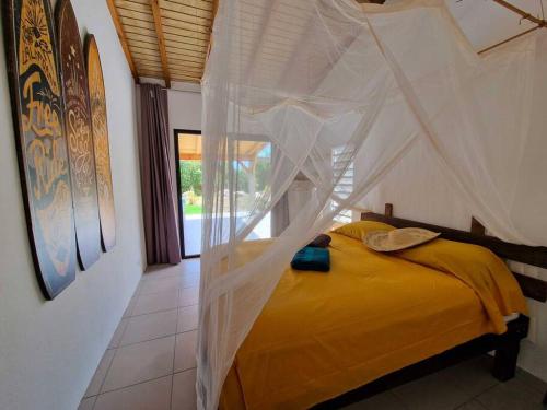 um quarto com uma cama e uma rede mosquiteira em Kazacactus-villa 3 chambres piscine Marie-Galante em Beauséjour