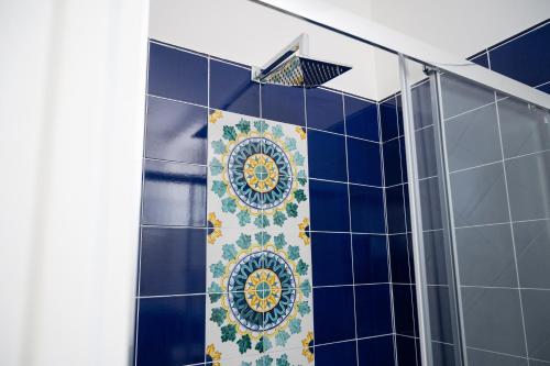 a blue tiled bathroom with a shower with a tile wall at B&B DieMme Amalfi Coast in Vietri sul Mare