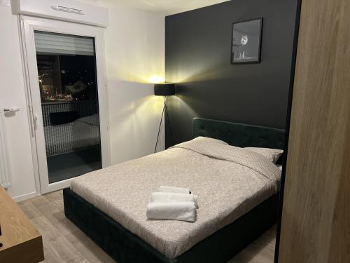 sypialnia z łóżkiem i dwoma ręcznikami na nim w obiekcie Gorgeous Apartment near Paris & Disneyland w mieście Fontenay-sous-Bois