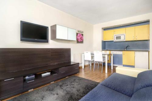 a living room with a couch and a flat screen tv at Ideal familias zona infantil y vistas a pistas in Candanchú