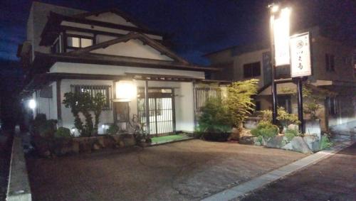 a building with a sign in front of it at night at Travel Inn Ikuta in Minabe