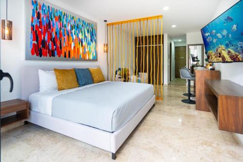 une chambre avec un lit blanc et un bureau dans l'établissement Midtown 2 by Andiani Travel, à Playa del Carmen