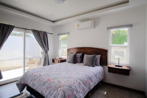 um quarto com uma cama grande e 2 janelas em Casa de Sara em Villa de Juárez