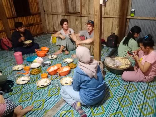 a group of people sitting on the floor eating food at RAMMANG-RAMMANG HOUSE in Maros