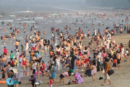 a large crowd of people on a beach at Thanh Nam Hotel in Dong Quan