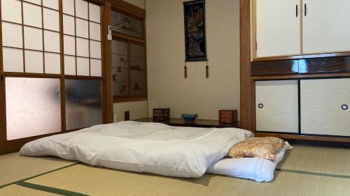1 dormitorio con 1 cama blanca en una habitación con ventanas en Guest House Yasuragi Kamigoto - Vacation STAY 45616v, en Shinkamigoto