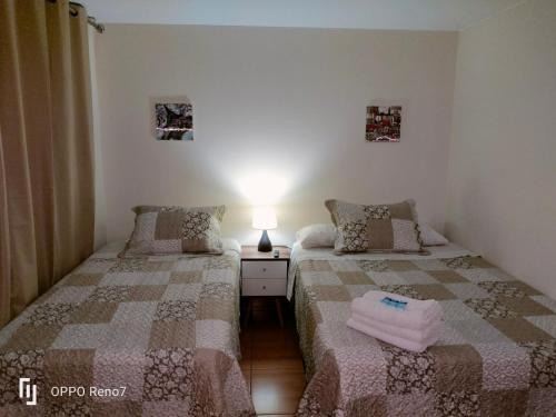 ein Schlafzimmer mit 2 Betten und einer Lampe auf einem Tisch in der Unterkunft Warmisitay HOME in Lima