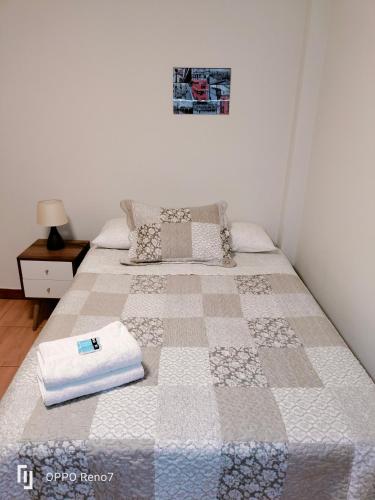 Una cama con edredón en un dormitorio en Warmisitay HOME, en Lima