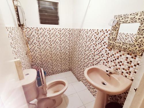 ein Badezimmer mit Toilette und Waschbecken in der Unterkunft Coron Town Traveller's Dormitory in San Nicolas
