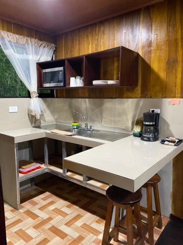 a kitchen with a sink and a counter with stools at Villas Cacao in Fortuna