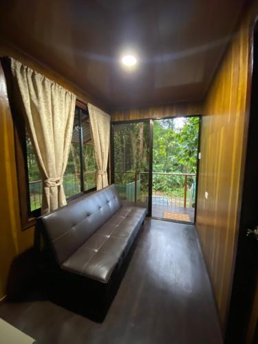 a couch in a room with a large window at Villas Cacao in Fortuna