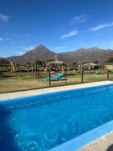 HijuelasにあるLoft 1 con tinaja para parejaの遊び場と山々を背景にしたスイミングプール